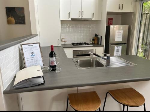 a kitchen with a sink and a counter with a bottle of wine at Lake Esmond Place in Canadian