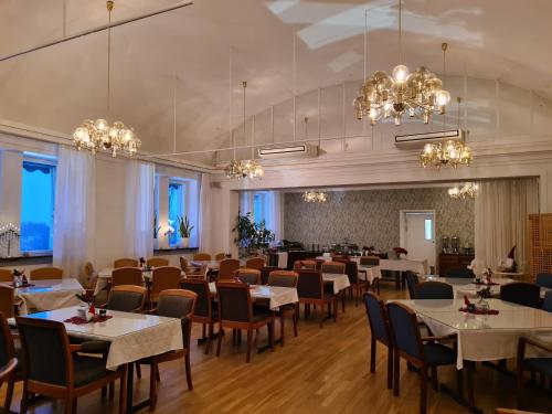 un comedor con mesas, sillas y lámparas de araña en Furunäset Hotell & Konferens en Piteå