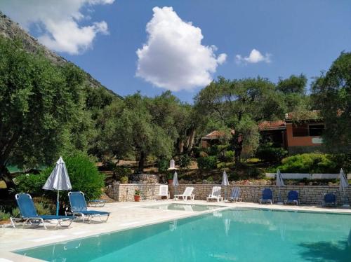 una piscina con sedie e ombrelloni in un resort di Villa Stefanos Apartments by Hotelius a Glyfa