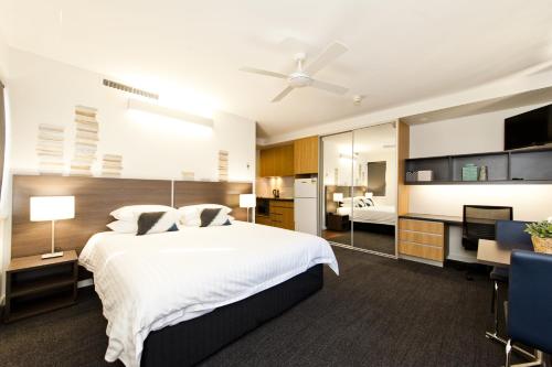 a hotel room with two beds and a television at St Catherine's on Park in Perth