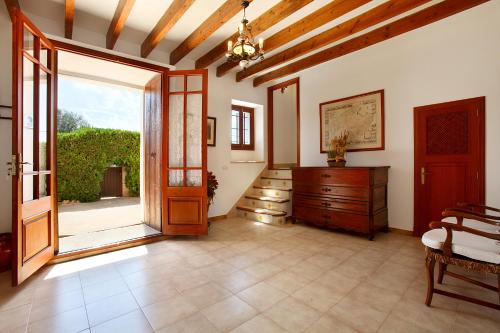 a large room with a wooden door and a dresser at Finca Teuler Petit in Caʼs Concos