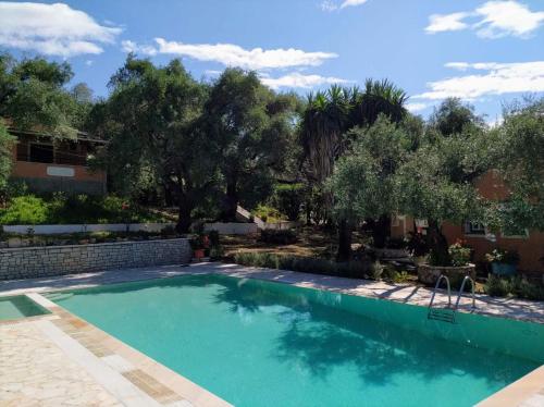 een zwembad in een tuin met bomen bij Villa Stefanos Apartments by Hotelius in Glyfa