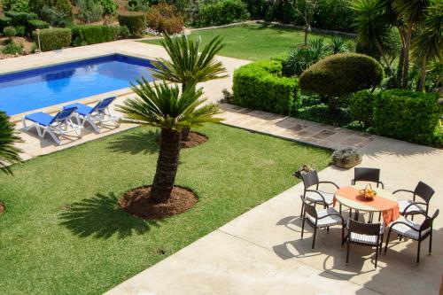 a patio with a table and chairs next to a pool at Finca Teuler Petit in Caʼs Concos