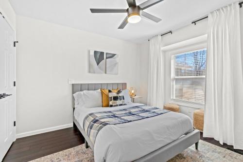 a white bedroom with a bed and a ceiling fan at The Americana in Bella Vista