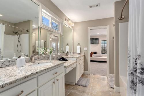 La salle de bains est pourvue de 2 lavabos et d'un grand miroir. dans l'établissement The Ritz, à Fayetteville