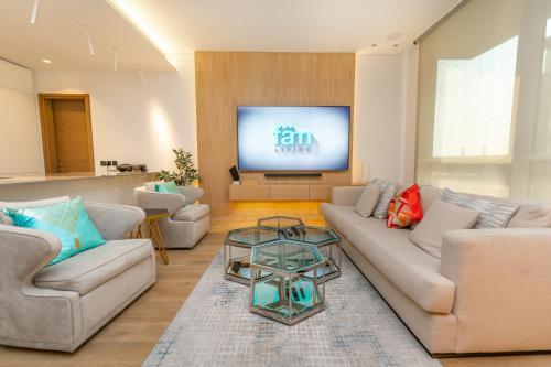 a living room with two couches and a flat screen tv at FAM Living - City Walk - Luxe Interiors in Dubai