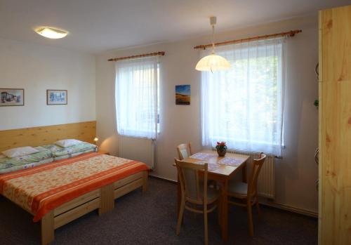 1 dormitorio con cama, mesa y comedor en Apartman 300 en Janske Lazne