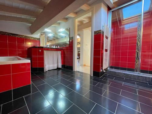 un bagno rosso con vasca e piastrelle rosse di CAMERE private a Porto Azzurro