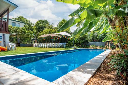 a swimming pool in the backyard of a house with a table and chairs at OXLEY Private Heated Mineral Pool & Private Home in Brisbane