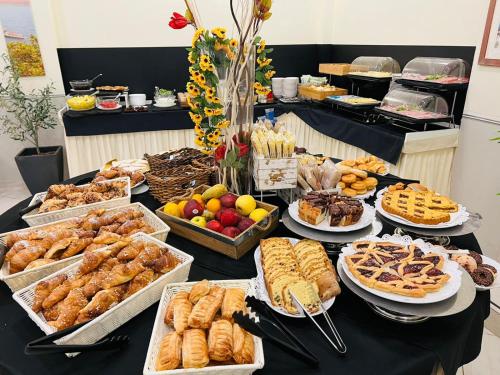 a table filled with different types of pastries and desserts at CDH Hotel La Spezia in La Spezia