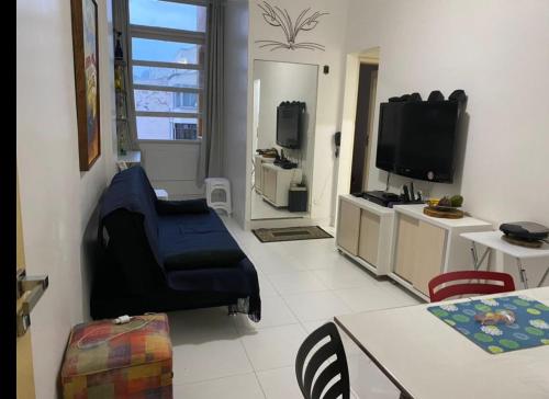 een woonkamer met een tv en een tafel en stoelen bij Apartamento copacabana Beach in Rio de Janeiro