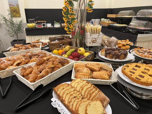 a table filled with different types of pastries and pies at CDH Hotel La Spezia in La Spezia