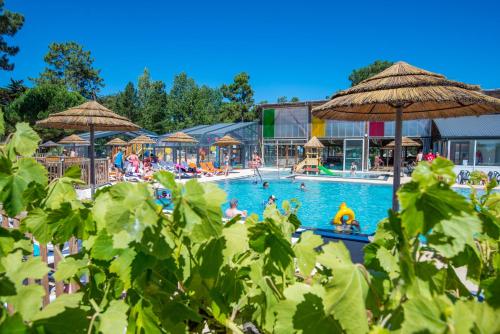 a pool at a resort with people in it at Camping Signol in Boyard-Ville