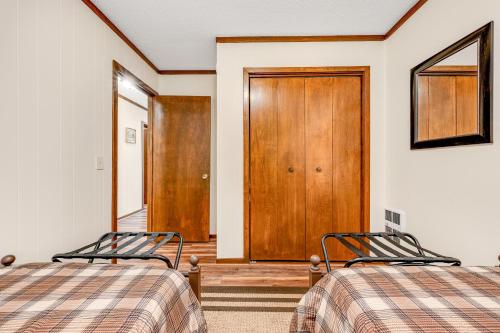 a bedroom with two beds and a wooden door at Serene Green Sanctuary in Beech Mountain