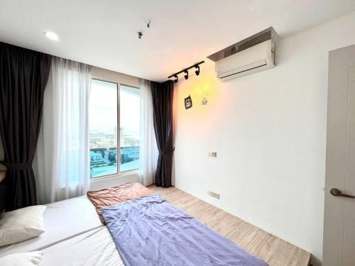 a bedroom with a bed with a large window at Concept Suite 05 @ The Wave Residence in Tranquerah