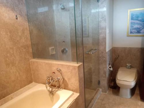 a bathroom with a shower and a tub and a toilet at Fantastic appartment at times square Kuala Lumpur in Kuala Lumpur