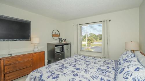 a bedroom with a bed and a tv and a window at Heated Pool, Bunk Beds, King Bed, Huge TV, Marina, Tiki Bar in Sarasota