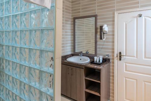 a bathroom with a sink and a mirror at Hotel Waterbuck in Nakuru