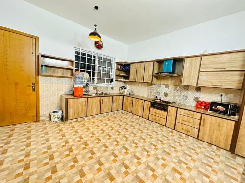 a kitchen with wooden cabinets and a wooden floor at Islamabad Travelodge Guest House in Rawalpindi