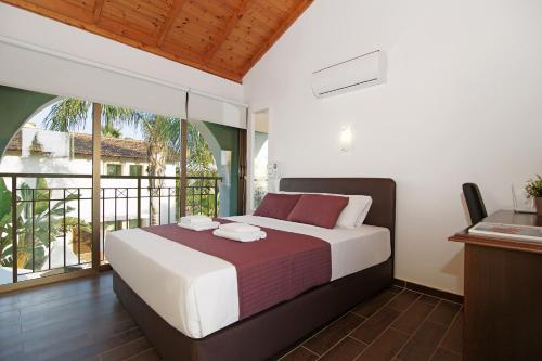 a bedroom with a large bed and a balcony at Villa Regina in Ayia Napa