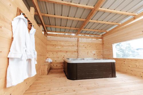 a sauna with a soaking tub in a wooden room at Les Loges du Léman in Crozet