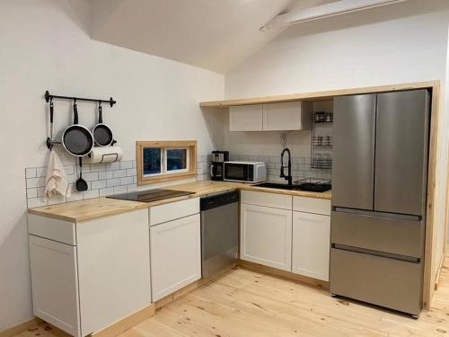 eine Küche mit weißen Schränken und einem Kühlschrank aus Edelstahl in der Unterkunft Andes secluded Cottage in Margaretville