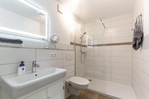 a white bathroom with a sink and a toilet at Ferienhof Marquardt Fewo Sperlingshöh in Wenkendorf