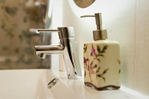 lavabo con dispensador de jabón junto a un grifo en Casa Rural Manitoba Luxe, en Buenache de la Sierra