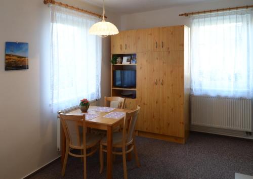 a dining room with a table and chairs and a cabinet at Apartman 300 in Janske Lazne