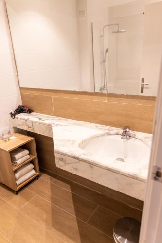 a bathroom with a tub and a large mirror at Hotel Can Pamplona in Vic