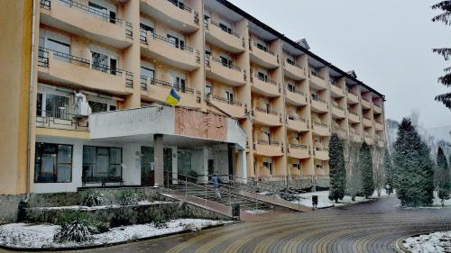 un gran edificio con nieve delante en Girska Tysa Health Resort, en Kvasy