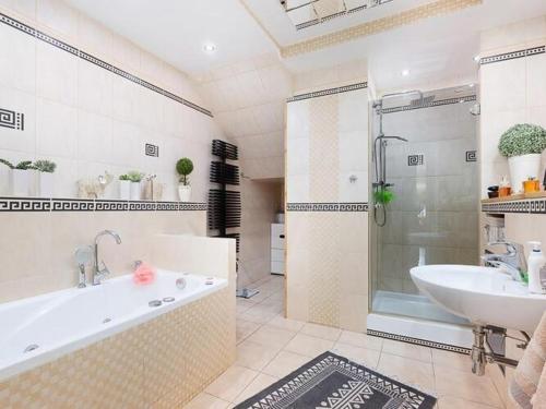 a bathroom with a tub and a sink and a shower at Comfortable 2-bedroom holiday apartment, pool, close to the beach, Rewal in Rewal