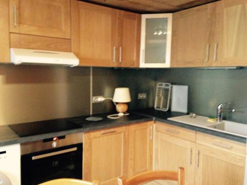 een keuken met houten kasten, een wastafel en een lamp bij Appartement Valloire, 4 pièces, 8 personnes - FR-1-263-178 in Valloire