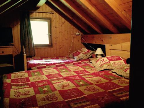 - une chambre avec un lit doté d'une couette rouge et blanche dans l'établissement Triplex cosy à Valloire - 8 pers, animaux admis, parking et wifi - FR-1-263-178, à Valloire