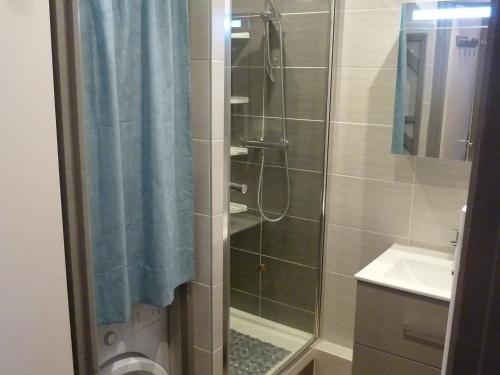 une douche avec un rideau de douche bleu et un lavabo dans l'établissement Studio cabine cosy 4 personnes, balcon sud, parking privé, centre Valloire, proche télécabine. - FR-1-263-14, à Valloire