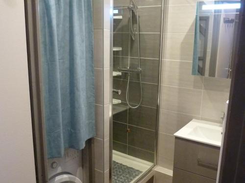 a shower with a blue shower curtain and a sink at Studio Valloire, 1 pièce, 4 personnes - FR-1-263-14 in Valloire