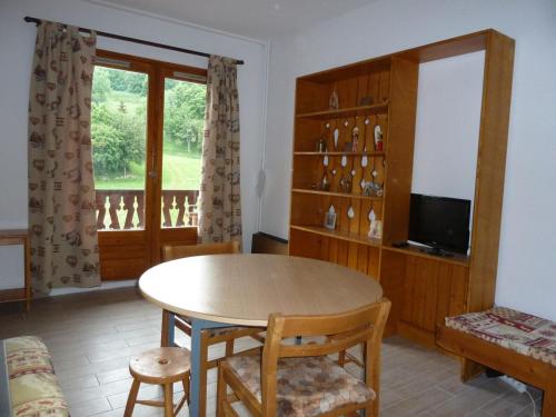 un salon avec une table et une télévision dans l'établissement Studio confortable pour 2 avec balcon exposé Sud à Valloire, près des pistes et des commerces - FR-1-263-29, à Valloire