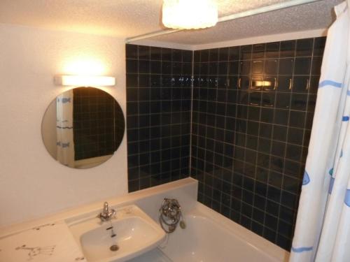 a bathroom with a sink and a tub and a mirror at Studio Valloire, 1 pièce, 2 personnes - FR-1-263-29 in Valloire