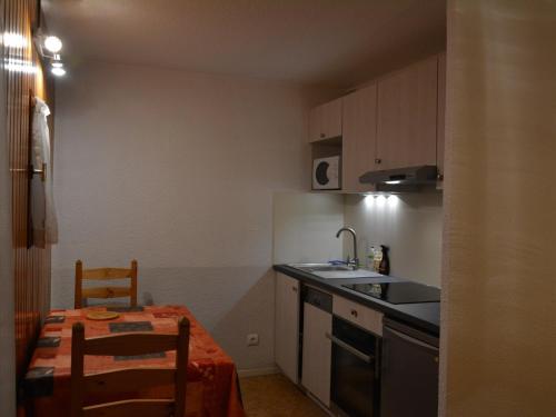 une petite cuisine avec une table et un évier dans l'établissement Appartement 2 pièces cabine, balcon, proche remontées mécaniques et loisirs, idéal 4 personnes - FR-1-263-32, à Valloire
