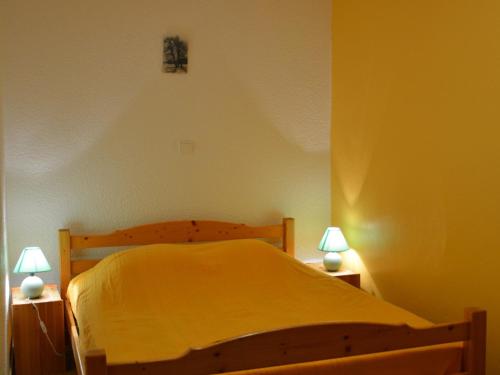 - une chambre avec un lit jaune et deux lampes dans l'établissement Appartement 2 pièces cabine, balcon, proche remontées mécaniques et loisirs, idéal 4 personnes - FR-1-263-32, à Valloire