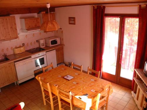 Il dispose d'une cuisine avec une table en bois et des chaises. dans l'établissement Charmant 3 pièces pour 6, balcon exposé Sud, au cœur de Valloire - FR-1-263-77, à Valloire