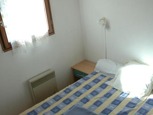 une petite chambre avec un lit et une fenêtre dans l'établissement Charmant 3 pièces pour 6, balcon exposé Sud, au cœur de Valloire - FR-1-263-77, à Valloire