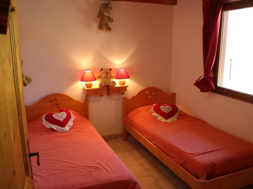 ヴァロワールにあるAppartement Valloire, 3 pièces, 6 personnes - FR-1-263-182のベッドルーム1室(赤いシーツとテディベアのベッド2台付)