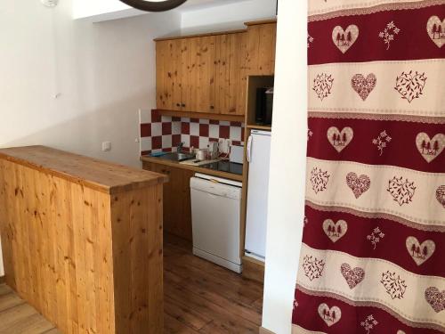 une cuisine avec un motif rouge et blanc sur le mur dans l'établissement Charmant 3 pièces 6 pers avec balcon et parking, à 700m du centre de Valloire - FR-1-263-222, à Valloire