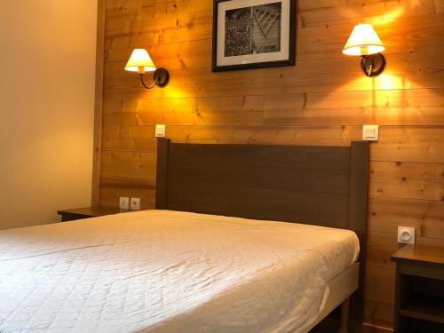 - une chambre avec un lit et deux lumières sur le mur dans l'établissement Charmant 3 pièces 6 pers avec balcon et parking, à 700m du centre de Valloire - FR-1-263-222, à Valloire