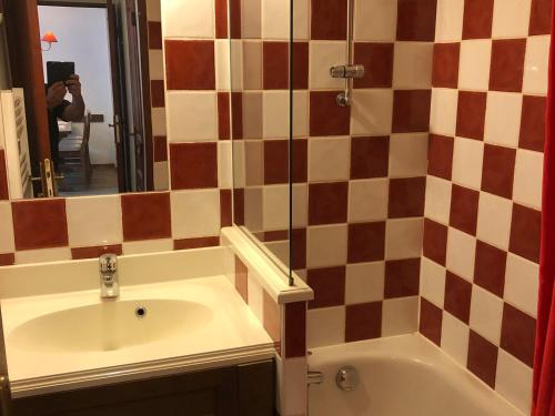 a bathroom with a sink and a tub and a mirror at Appartement Valloire, 3 pièces, 6 personnes - FR-1-263-222 in Valloire