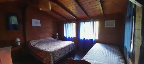 - une petite chambre avec 2 lits et une fenêtre dans l'établissement Cabaña clandestina, à Los Repollos