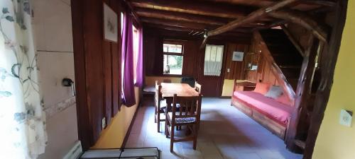 Cette chambre comprend une table, des chaises et un lit. dans l'établissement Cabaña clandestina, à Los Repollos