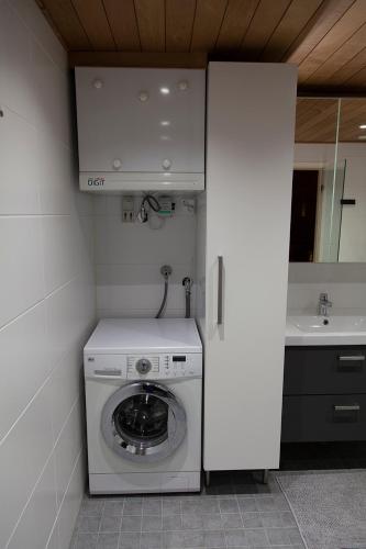 a washing machine in a bathroom with a sink at Seitapolku 12 Villa in Saariselka