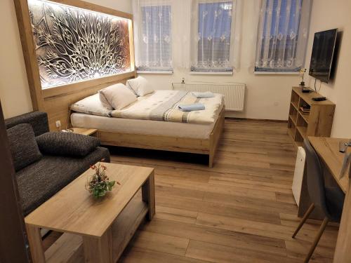 ein kleines Wohnzimmer mit einem Bett und einem Sofa in der Unterkunft Hotel Gól Prostějov in Prostějov